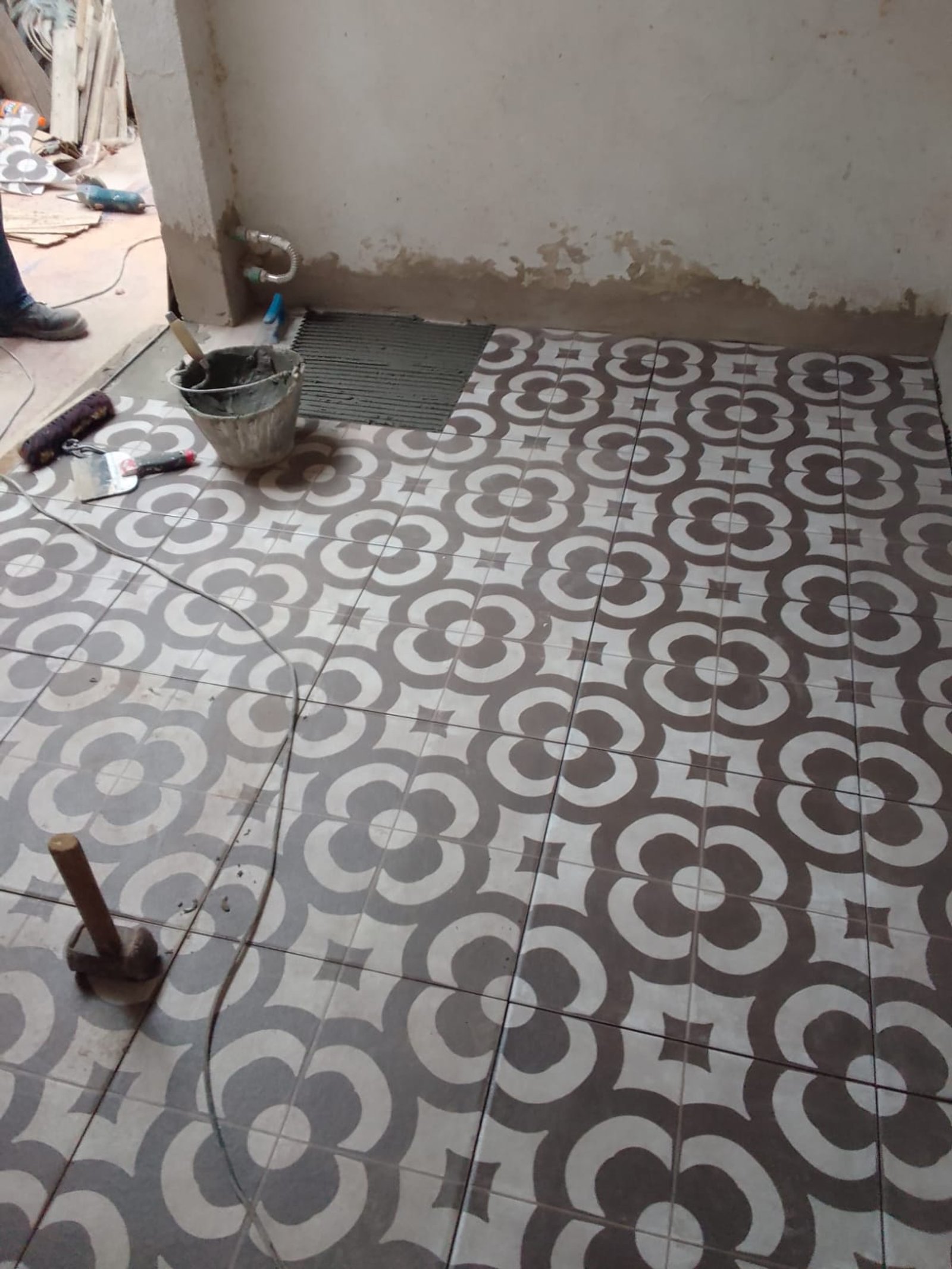 Obra en progreso con baldosas de flores y herramientas — proyecto 2 Casas en Lanus, por Arquitecto Guido Niccoli, en B1824 Lanús